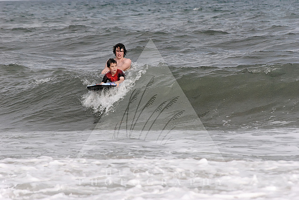 Big brother instructs sibling on surfing.