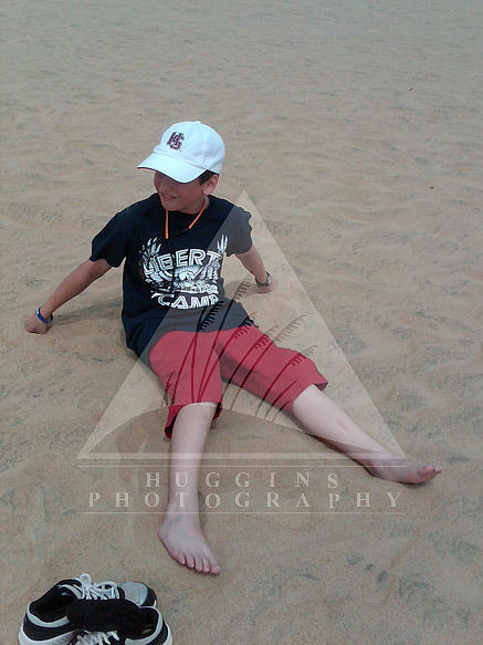 A boy relaxes on a sand dune